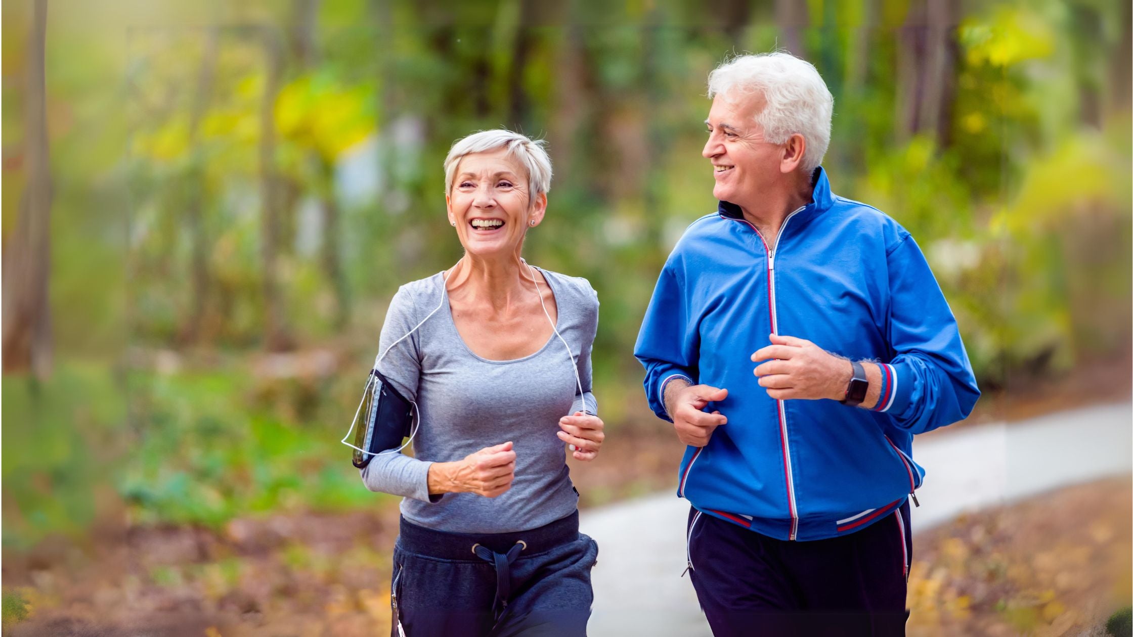elderly couple running together in the woods for exercise