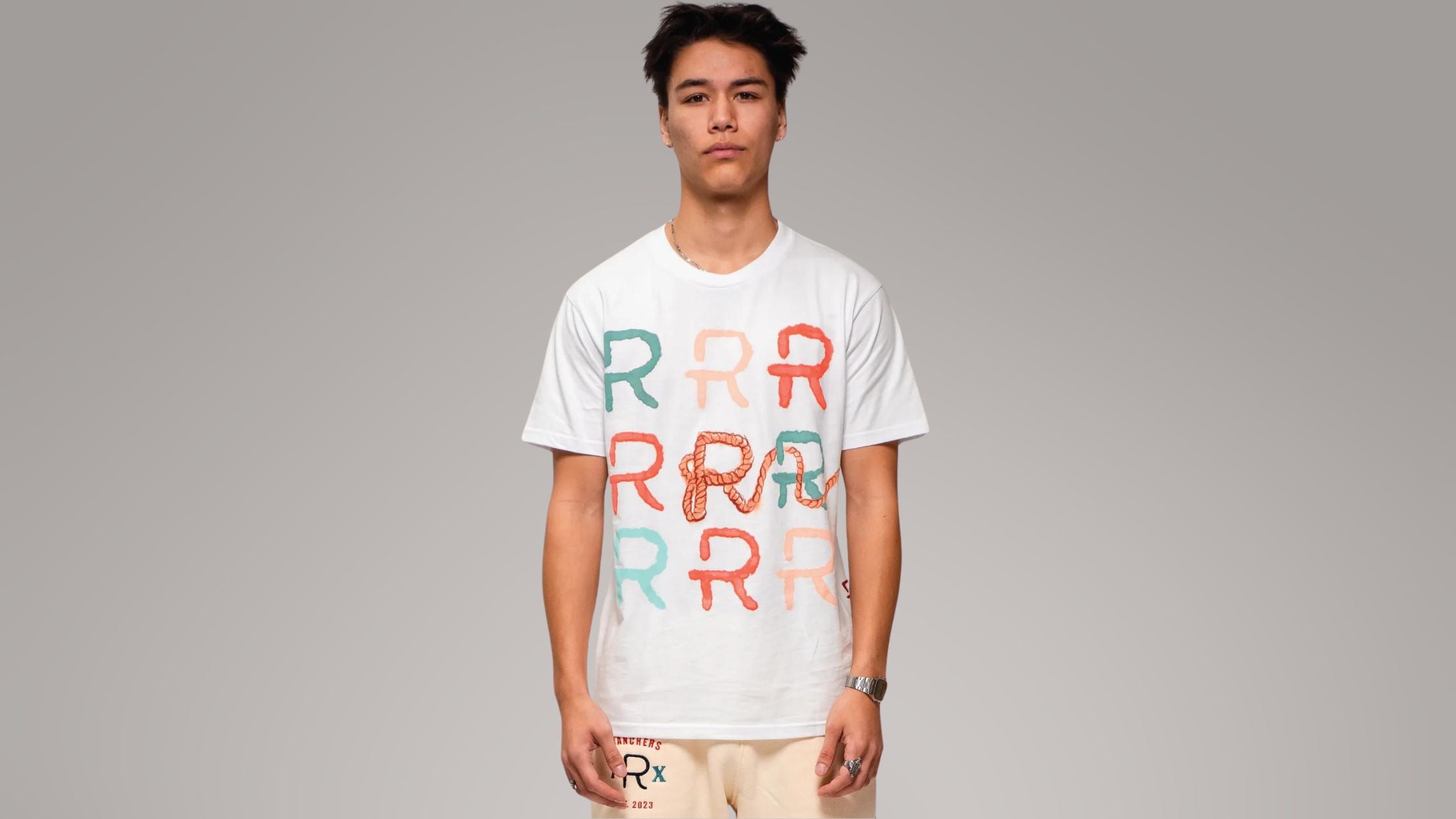 a man wearing a white lasso graphic tee by Ranchers
