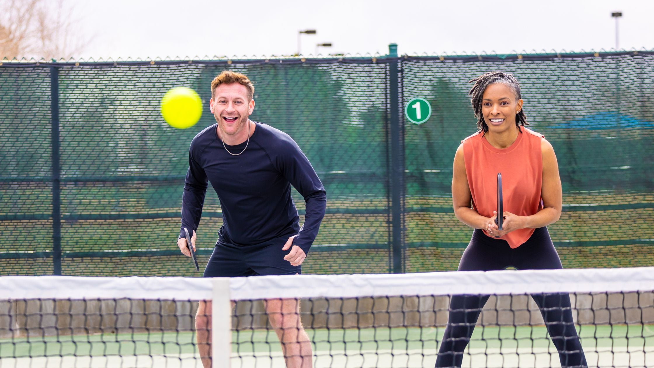 two people playing pickleball on a court