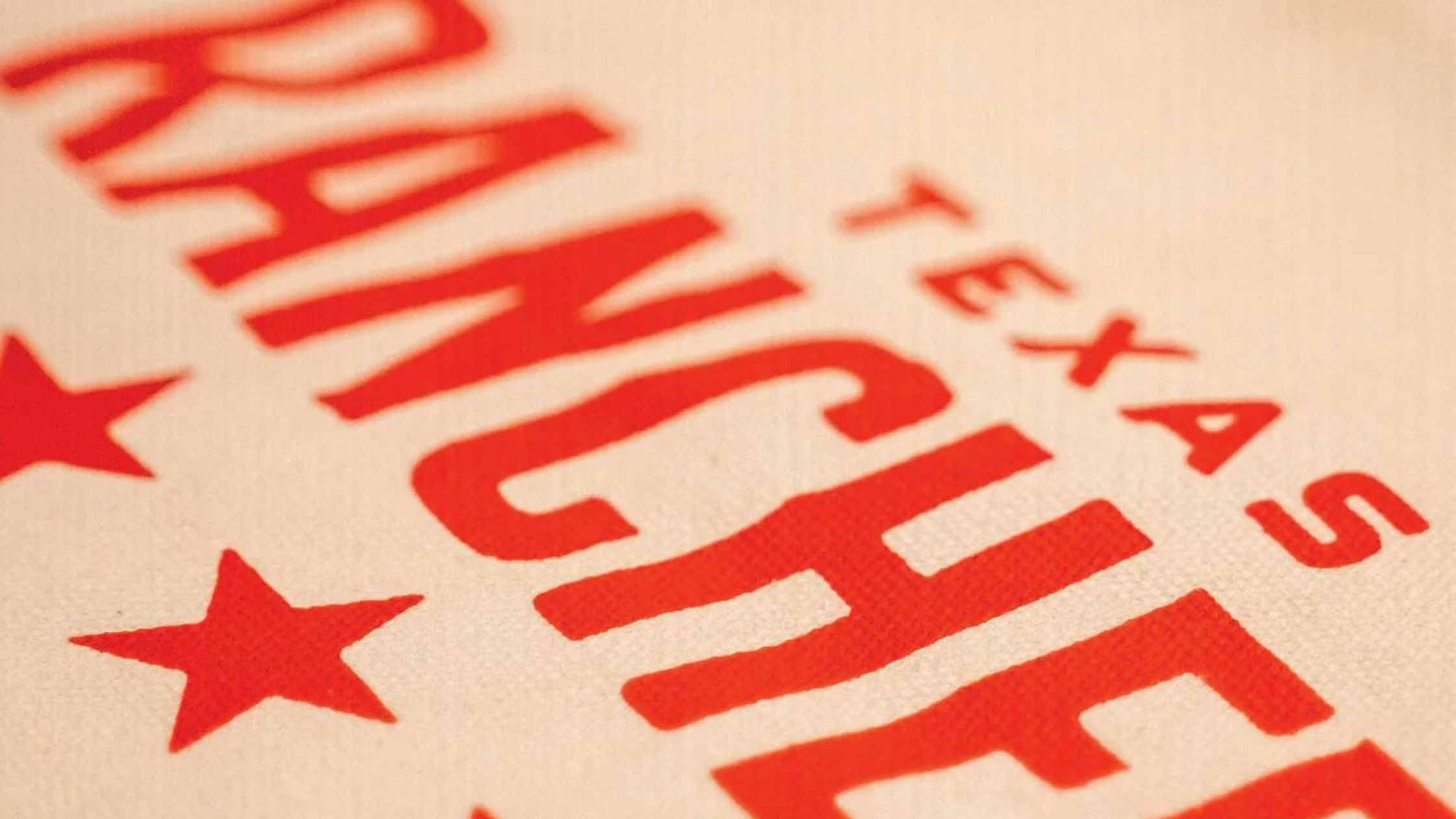 close-up of a Texas Ranchers tote bag featuring a red stars design