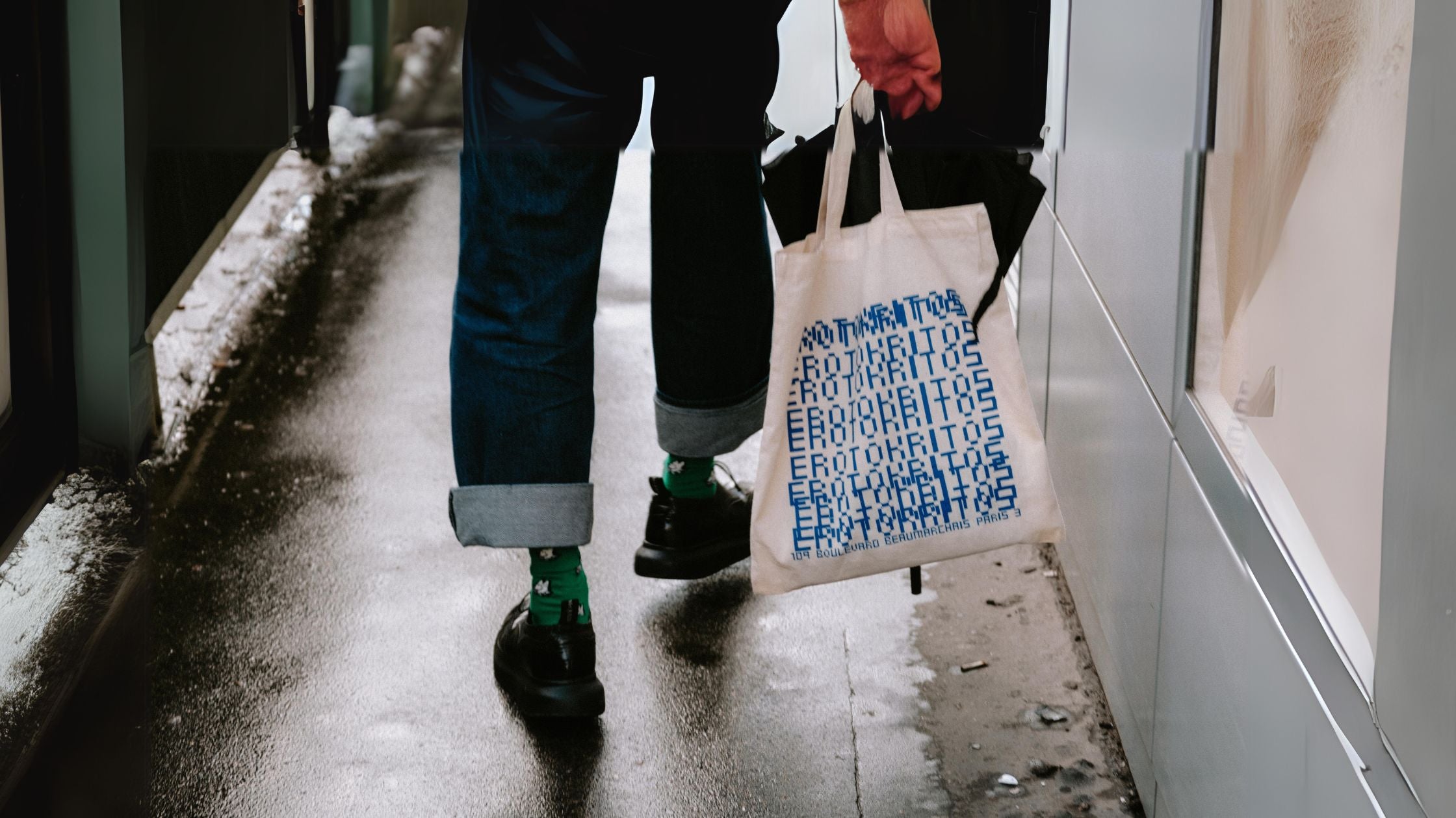 a person walking down a street holding a tote bag