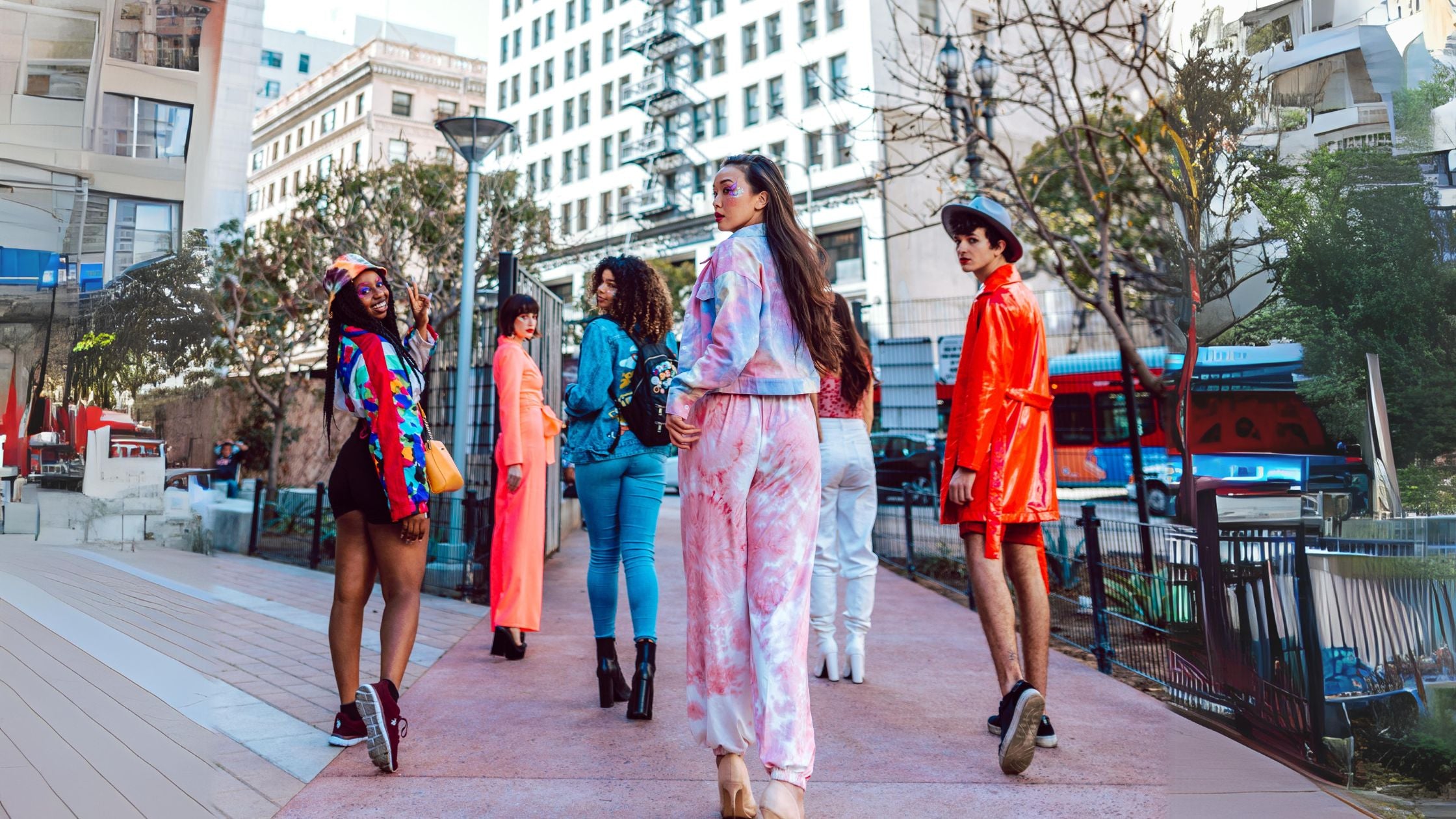 a group of young people walking down a city sidewalk