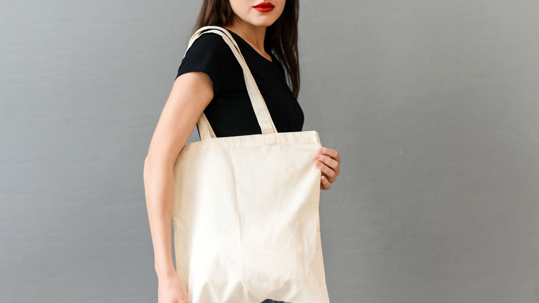 a woman in a black shirt carrying a customizable tote bag