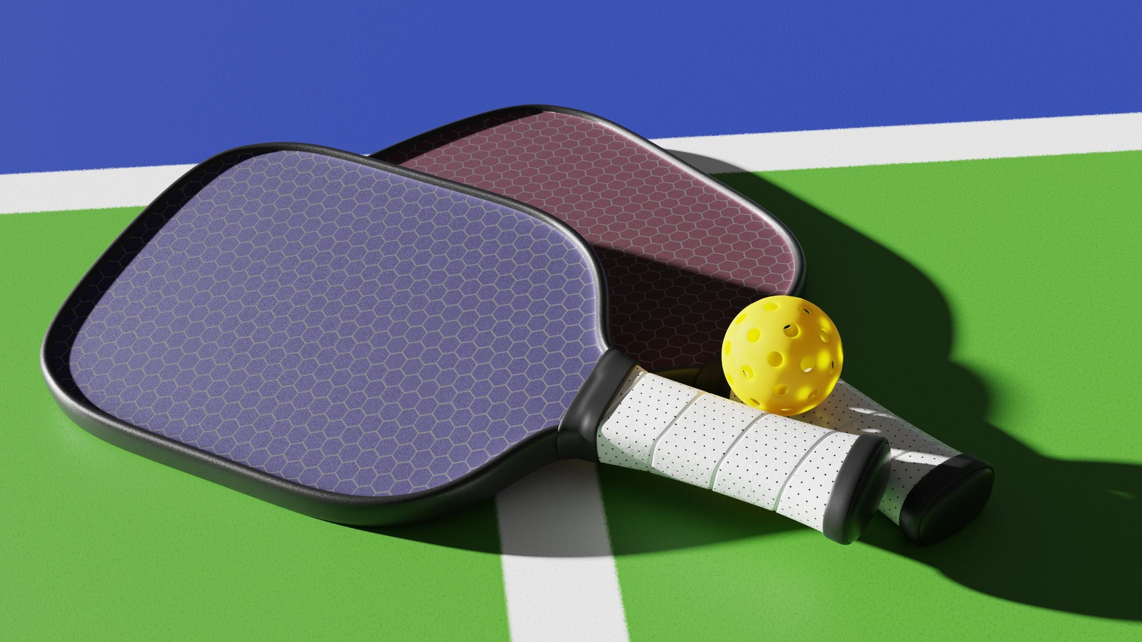 pickleball paddles and a ball on a green and blue court