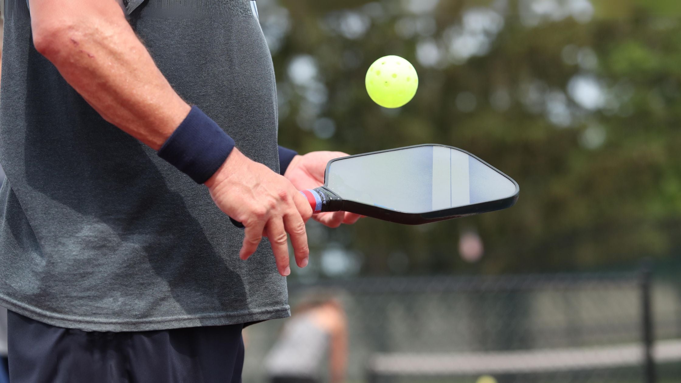 a male pickleball player with a paddle and ball